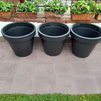 3 grossi vasi neri per fiori o piante.