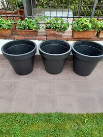 3 grossi vasi neri per fiori o piante.