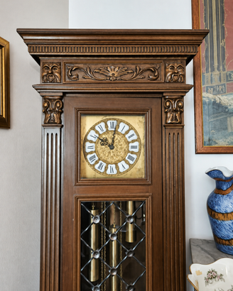 Orologio a pendolo antico in legno intagliato