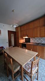 Cucina completa in legno con credenza e tavolo con