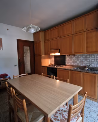 Cucina completa in legno con credenza e tavolo con