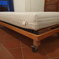 Letto singolo con materasso, rete a doghe e ruote.