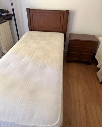 2 letti singoli con materasso e un comodino