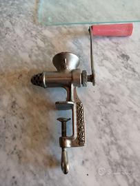 Tritacarne in ghisa a manovella, salsicce e salame