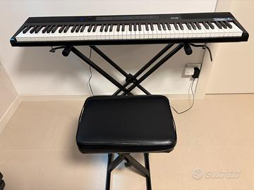 Tastiera, pianola con sgabello e supporto.