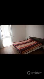 Letto matrimoniale con testiera in legno grigia