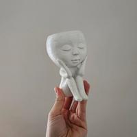 Vaso bianco con forma umana seduta
