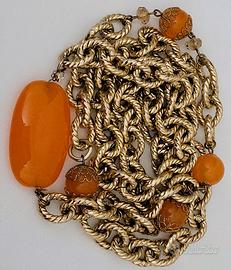 Collana dorata con pietre arancioni.