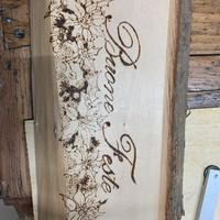 Scritta “Buone Feste” pirografata sul legno