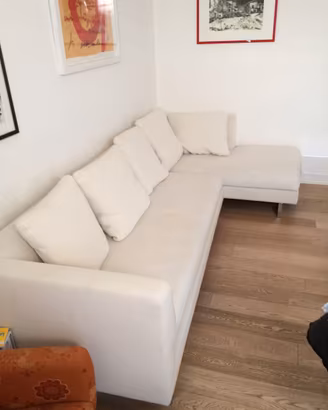divano bianco con chaise longue e cuscini