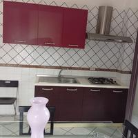 Cucina con tavolo e sedue e armadio a ponte per ca