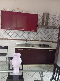 Cucina con tavolo e sedue e armadio a ponte per ca