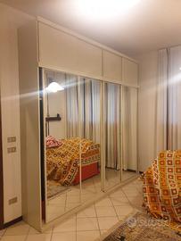 Mobile bianco con porte scorrevoli e specchi