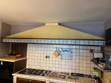 Cucina mattonelle in cotto e ante in noce.