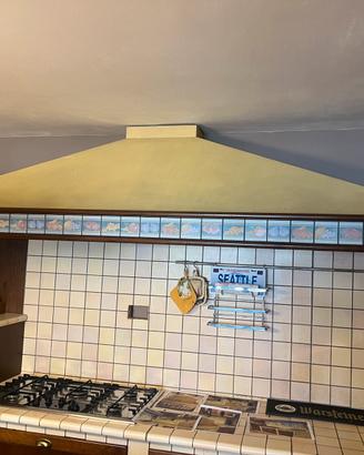 Cucina mattonelle in cotto e ante in noce.
