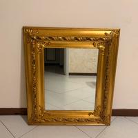 Specchio con cornice in legno dorato.