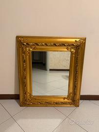 Specchio con cornice in legno dorato.