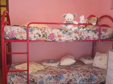 Letto a castello in metallo rosso con scaletta .