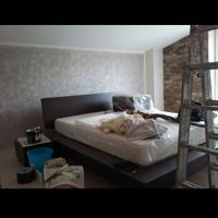 Letto tavolo divano e parete attrezzata