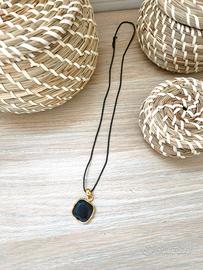 Collana con pendente nero e dettagli oro
