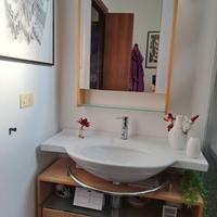 Arredo bagno con lavabo, rubinetto  e specchio.