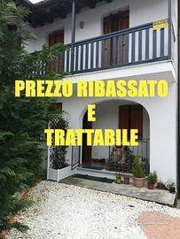 Casa affiancata ad L in contesto collinare