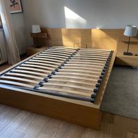 Letto matrimoniale con comodini e cassettone.