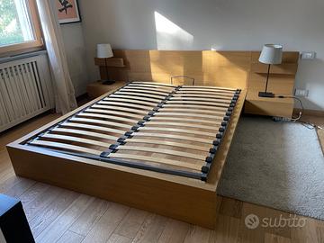 Letto matrimoniale con comodini e cassettone.