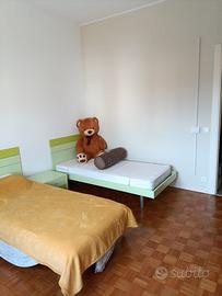 Cameretta con due letti, scrivania e mensole