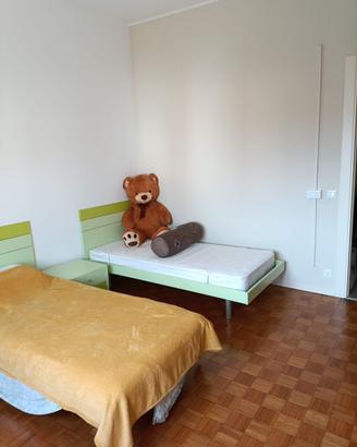 Cameretta con due letti, scrivania e mensole