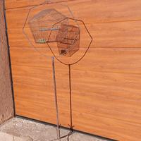 voliera in ferro battuto con appesa gabbietta