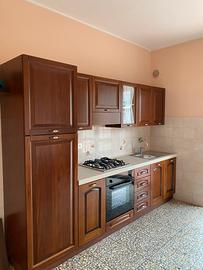 Cucina lineare in legno con tavolo e 4 sedie
