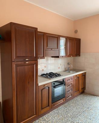 Cucina lineare in legno con tavolo e 4 sedie