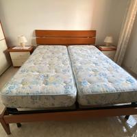 Letto matrimoniale con due comodini e materassi