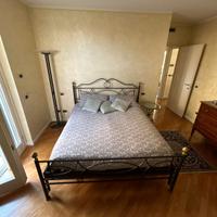 Letto matrimoniale con tavolino e lampada