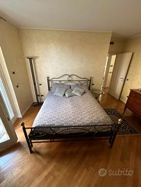 Letto matrimoniale con tavolino e lampada