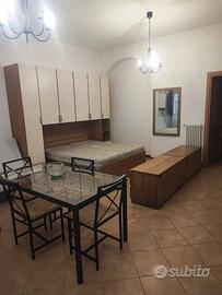 Armadio a ponte, letto e specchio