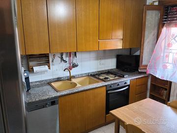 Cucina con elettrodomestici, tavolo e 4 sedie