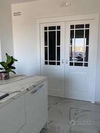 Porta doppia scorrevole bianca con vetro – 140 cm
