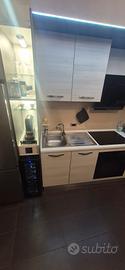 cucina completa e tavolo con sedie 