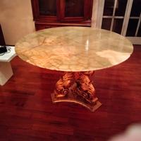 tavolo tondo con piano in onice e base intagliatoa