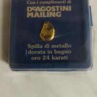 Spilla dorata realizzata da De Agostini Mailing