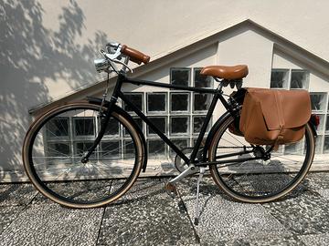 Bicicletta vintage nera con borse cuoio