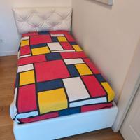 Letto singolo con rete e materasso.