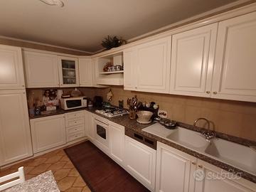 cucina con tavolo ed elettrodomestici