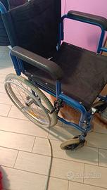 carrozzina pieghevole per disabili di colore blu.