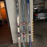 tre paia di sci con bastoncini