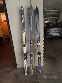 tre paia di sci con bastoncini