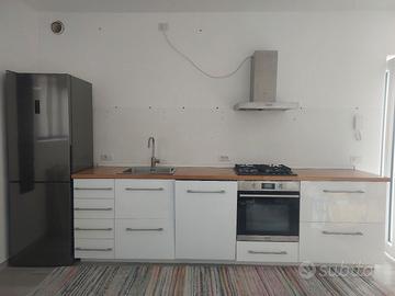 Cucina lineare bianco con piano cottura e lavello