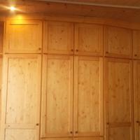 armadio in abete spizzato con varie ante e ripiani